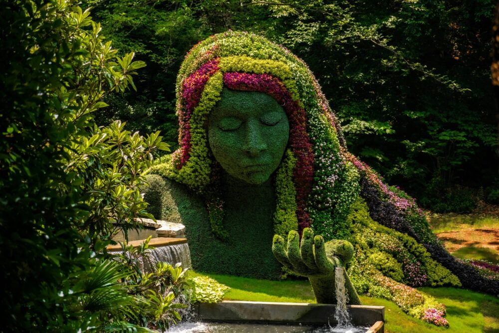 Sculpture of woman made of bushes and flowers