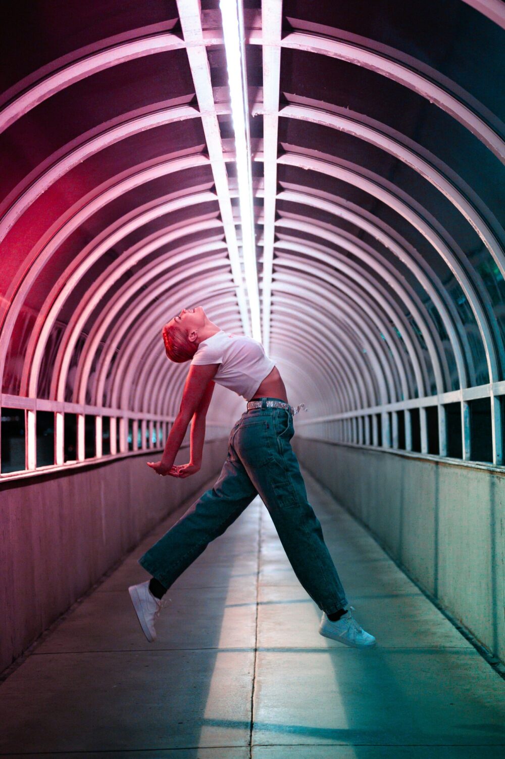 person dancing inside a walkway with neon lights on