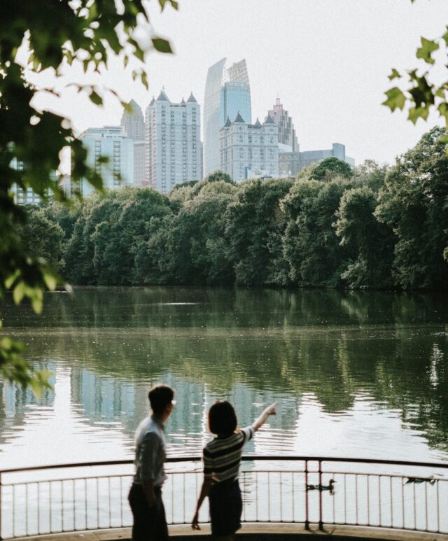 Two people overlooking water and city