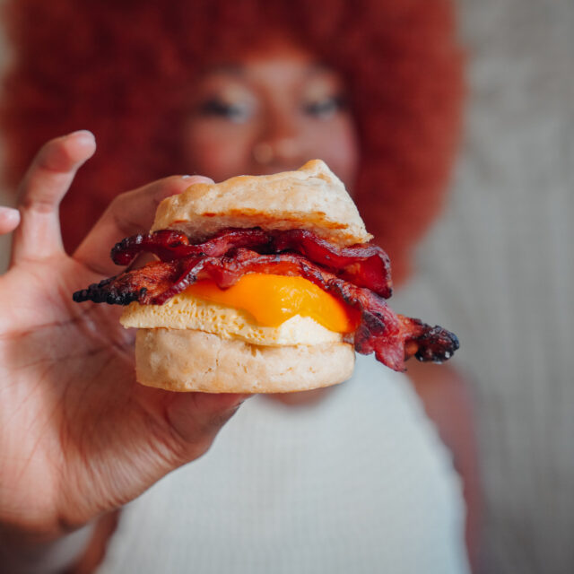Woman holding breakfast sandwich